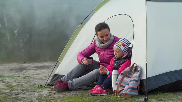 Little Girl with Mother Having Breakfast in Tent