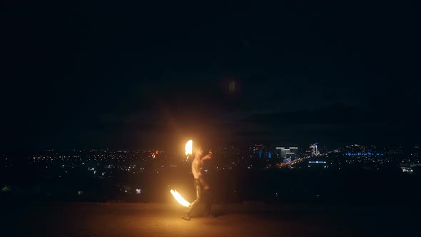 Young Blond Male Dances with Two Burning Torches