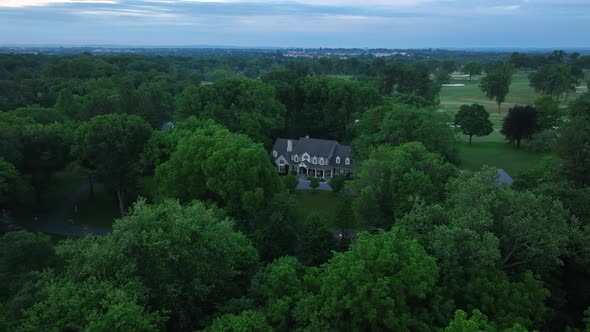 Aerial view of an estate on large plot of land near a country club. Private mansion surrounded by tr