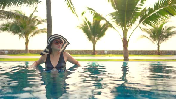 Young asian woman enjoy around outdoor swimming pool for leisure