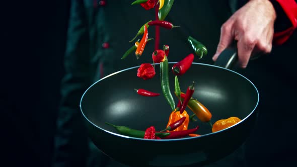 Super Slow Motion Shot of Chef Holding Frying Pan and Falling Chilli Peppers at 1000Fps.