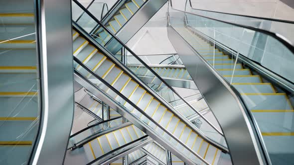 Puzzling labyrinth of escalators made of glass and steel. Complicated passages.