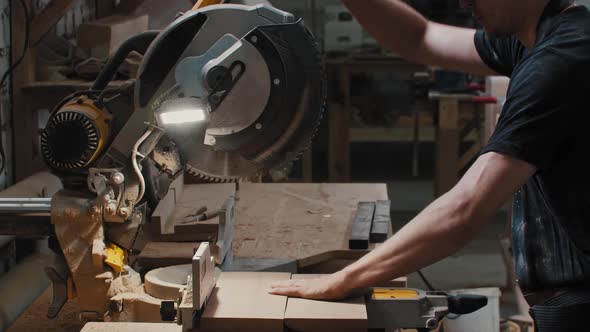 Carpentry Works  Worker Puts Down a Big Circular Saw Over the Wooden Detail