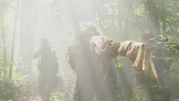 Marine Corps Detachment in Combat Gear Moving Forward in Fog of Forest