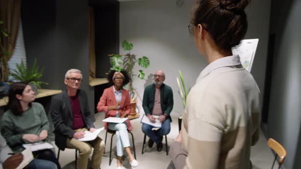 Young Woman Giving Speech at Business Seminar with Coworkers