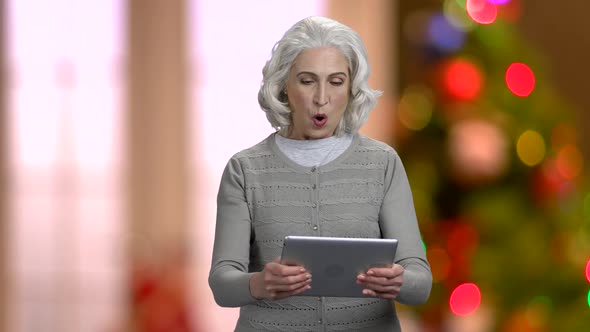 Excited Senior Woman Playing Game on Digital Tablet