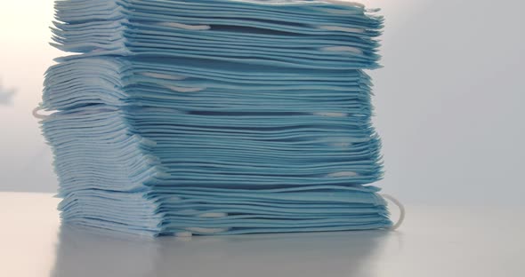 Close-up of Blue Medical Masks on the Table, Camera Moving Up Along Stack of Protective Antiviral