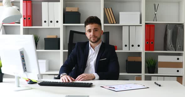 Young Businessman Making Gesture with Hand and Looking at Camera