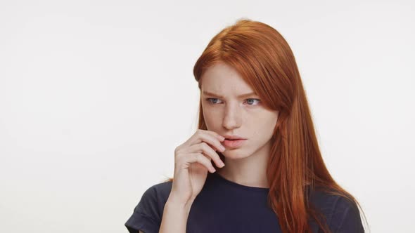 Thoughtful Redhaired Caucasian Teenage Girl Wearing Dark Blue Tshirt Trying to Remember Something on