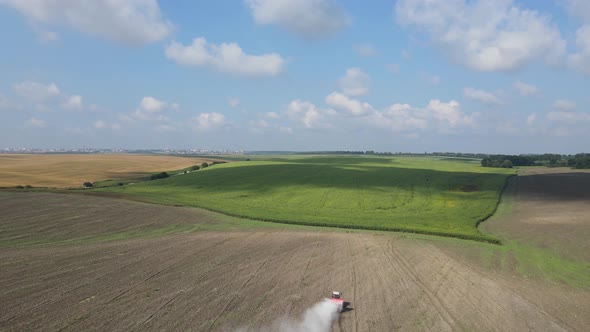 The Tractor Spreads Fertilizer On The Field 