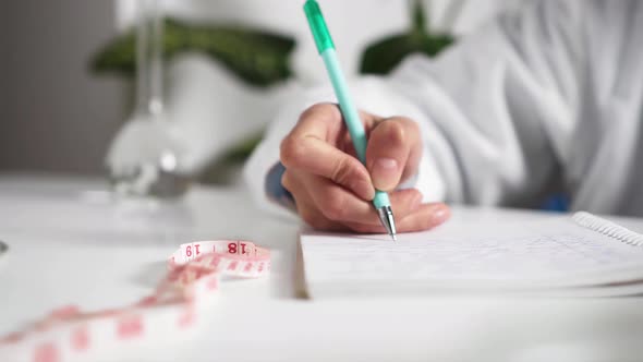 Doctor's Hand Close Up Writes Fills Out The Documentation, The Medic Works At The Workplace