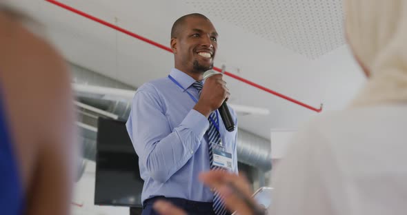 Male speaker addressing applauding audience at a business seminar