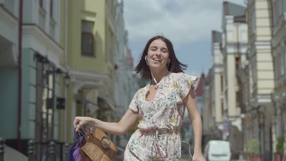 Cute Cheerful Young Woman with Shopping Bags