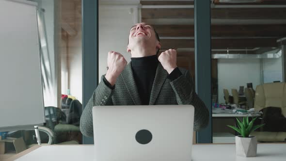 Overjoyed Businessman Sit at Desk Look at Laptop Screen Scream Celebrating Success Win