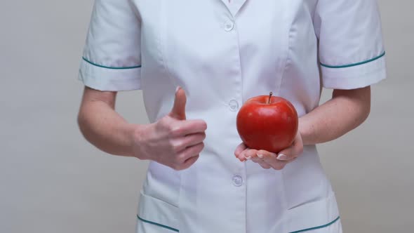 Nutritionist Doctor Healthy Lifestyle Concept - Holding Red Apple and Medicine or Vitamin Pill