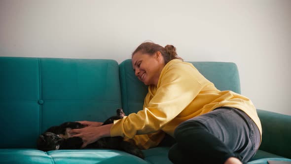 A Young Adult Cheerful Woman Playing with Her Cute Cat