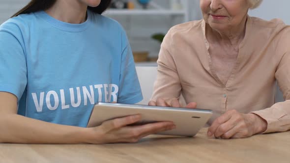 Young Volunteer and Retired Lady Scrolling Tablet and Smiling to Camera, Banking