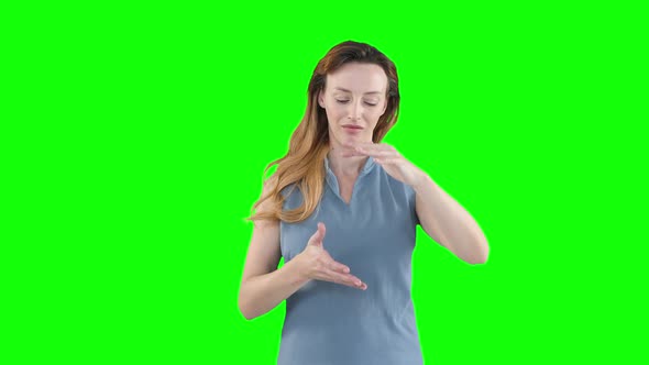 Caucasian woman raising hands on green background