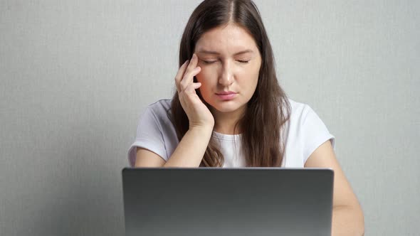 Woman with Poor Eyesight Looks at Laptop Screen Squinting