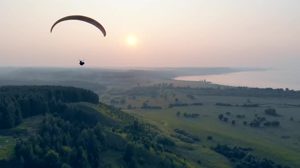 Sunset Landscape and a Person Flying the Paraplane