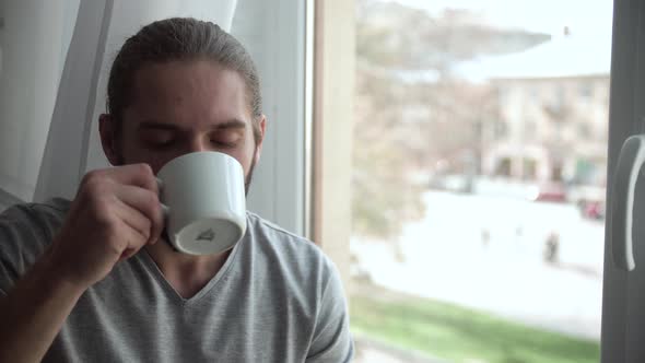 Man Drinking Coffee And Enjoying View From Window