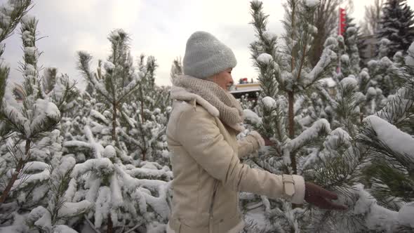 Beautiful Woman Standing Among Snowy Trees in Winter Forest and Enjoying First Snow