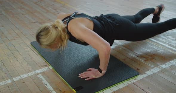 Athletic Woman with Smart Watch Does Pushups As Part of Her Cross Fitness