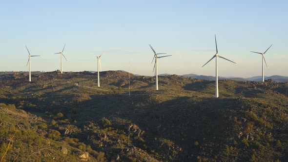 Sortelha nature landscape view with mountains, trees, boulders and wind turbines at sunset, in Portu