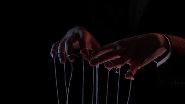 Puppeteer Manipulating and Pulling Strings of Marionettes