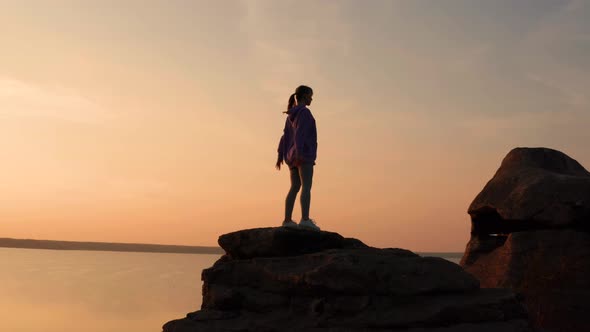 A Girl Does Fitness on a Hill at Sunset