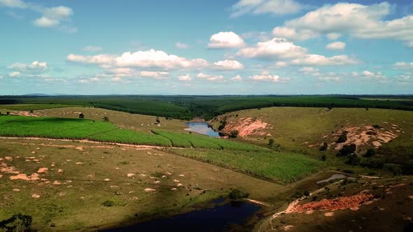 Incredible cinematic drone aerial flying over a wide valley field landscape with blue sky and clouds