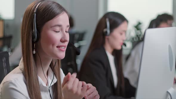 Close Up Portrait of a Technical Customer Support Specialist Talking on a Headset While Working on a