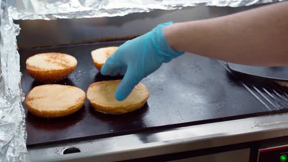 Burger Buns Heating Up on Professional Grill in Industrial Kitchen