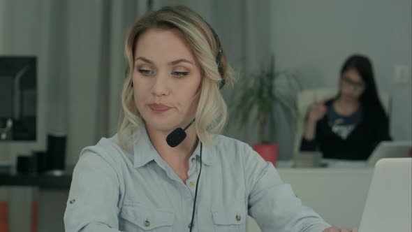 Call Center Employee Making Notes While Talking with Customer