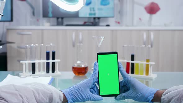Scientist Holds a Smarphone with Isolated Green Screen Mock-up