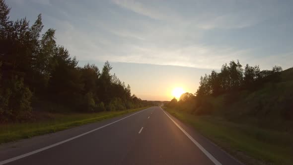 Driving along a rural road at sunset