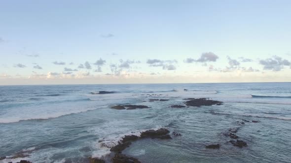 Flying Over Black Volcanic Stones in Coastal Ocean Water