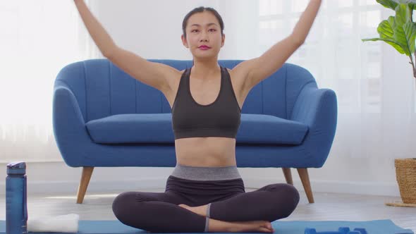 Calm of wellness Asian young woman sit on carpet breathing with yoga lotus pose