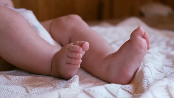 Tiny Babies Feet on White Blanket