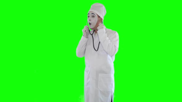 Funny Mime in White Robe with Stethoscope Imitating Work of the Doctor