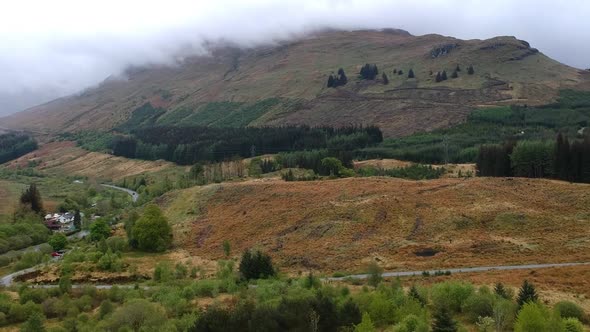 Drone reveal shot of misty highland mountain