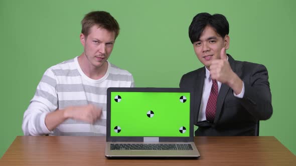 Young Asian Businessman and Young Scandinavian Businessman Working Together with Laptop