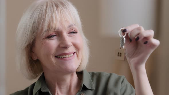 Overjoyed Happy Middleaged Senior 60s Caucasian Woman Holding Key Excited with Own House New Home