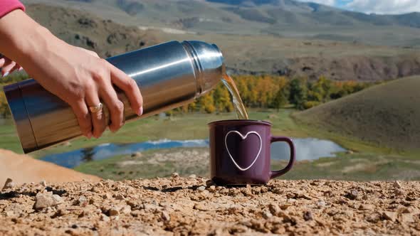 Hand of Woman Pouring Hot Tea in Altai Mountains