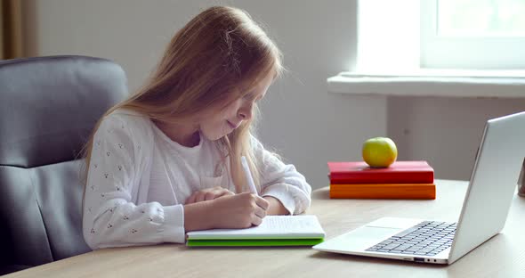 Happy Little Primary School Girl Doing Homework Alone Remotely From Home Room. Smart Cute Small