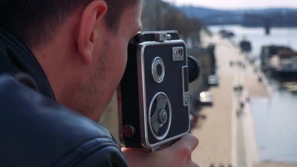 A Man Shoots a Video of a Boat at a Port on a River