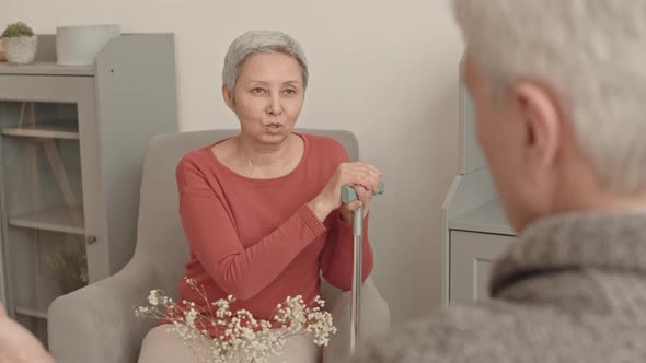 Senior Woman with Cane Talking to Partner