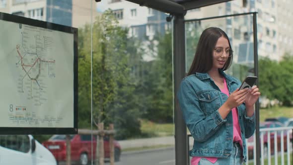 Young Stylish Woman Waiting for the Public Transport While Standing at the Modern Tram Station