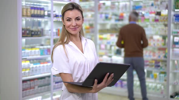 Portrait of Young Confident Beautiful Woman with Digital Tablet Looking at Camera Standing in