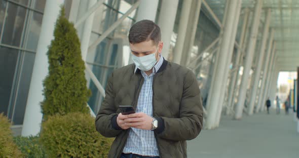 Young Man Wearing Protective Face Mask Use Phone COVID-19 Coronavirus Infection Near Airport